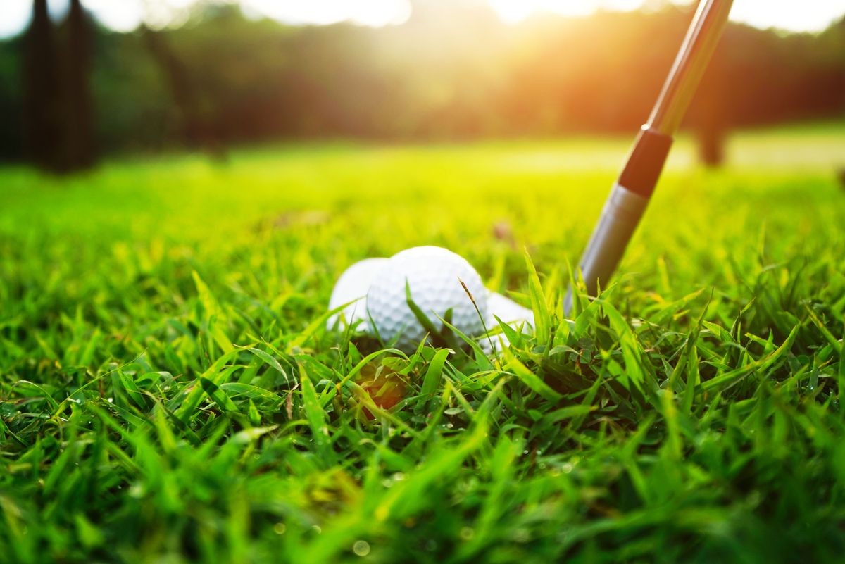 Blurred golf ball and golf club in beautiful golf course at sunset background. Blurred golf ball and golf club in beautiful golf course at sunset background.